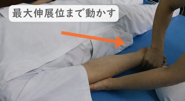 患者とセラピストの画像。患者の肘を完全伸展させたポジションまで他動運動させた様子。