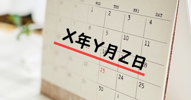 ピントがずれてぼやけた卓上カレンダー。X年Y月Z日のテキスト入り。