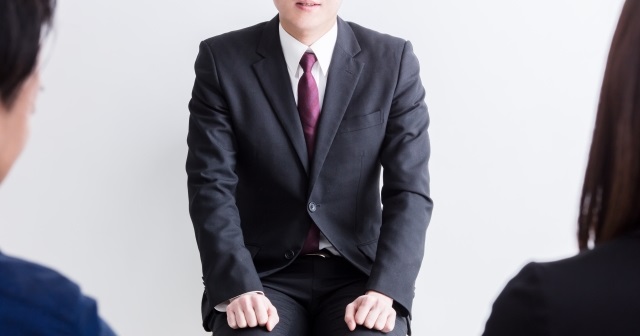 面接官２人と男性の就活生の面接風景。就活生は緊張している様子。