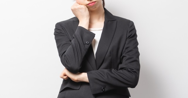 スーツ姿で考え事をする女性