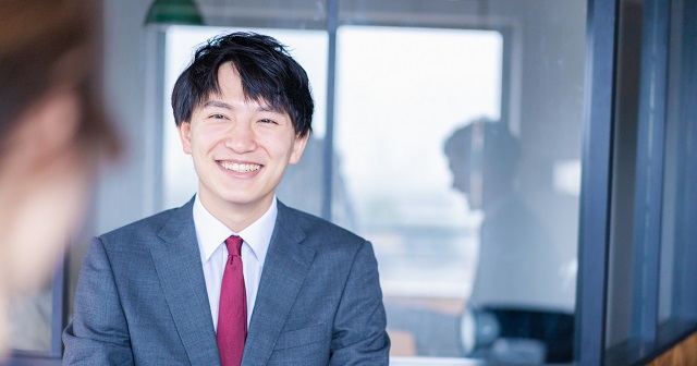 笑顔でさわやかな男性。リクルートスーツ姿で面接中の様子。