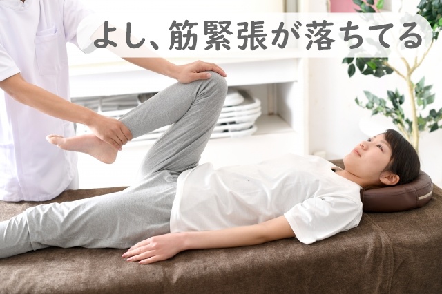 セラピストが患者の下肢を動かしている。「筋緊張が落ちているな」のコメントあり。